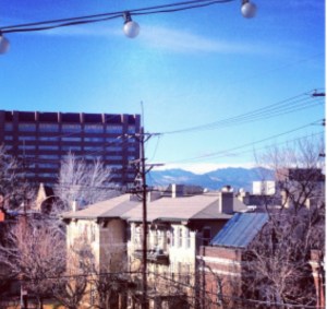 city as seen from a rooftop, mountains and telephone lines in background